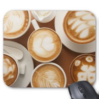 Close up of cups of cappuccino with different mouse pad