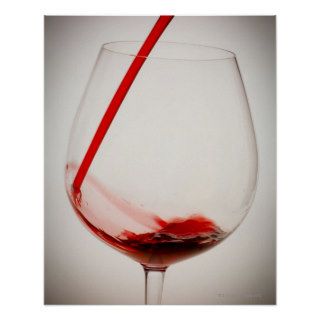 Red wine pouring into glass, close up print