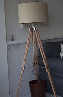 beech wooden tripod lamp by candle and blue